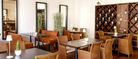 Un moderno vestíbulo de hotel con mobiliario de mimbre, una bodega de vino y espejos grandes.