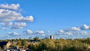 Paisatge urbà amb una combinació d'edificis moderns i tradicionals, cel blau clar i núvols dispersos.