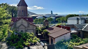 A church with a bell tower, surrounded by residential buildings and greenery. - Tamarisi Old Tbilisi (Tbilisi)