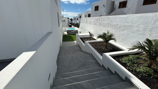 A narrow, white-walled corridor with a tiled staircase leading to a rooftop area. - Sunning 2 bedrooom apartment 5 minutes walk to seafront. (Tías)