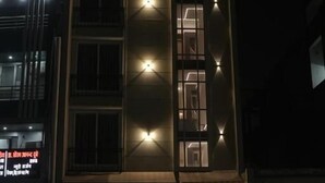 Un hotel llamado 'Madina Hotel' con una fachada moderna, señalización iluminada y una entrada visible.