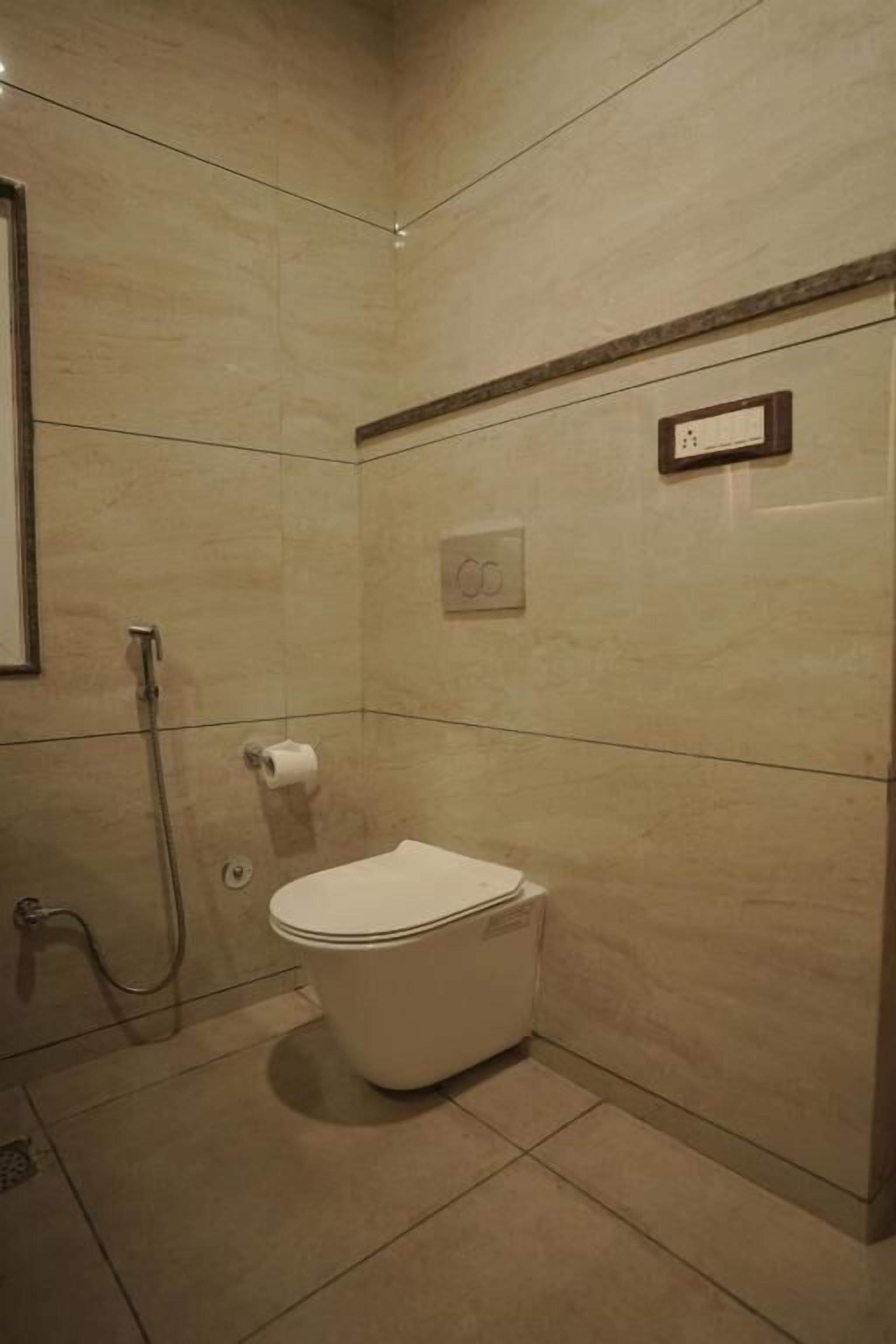 A small, modern bathroom with a toilet, a shower, and a towel rack.