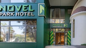 Exterior del Hotel Novel Park, con un letrero llamativo y la entrada.