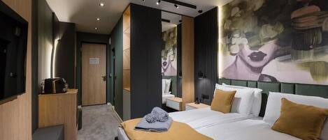 A modern hotel room with a large bed, a desk, and a seating area.
