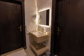 A modern bathroom with a large mirror, a sink, and a toilet. - ALFASWAL ALARBAAH SERVICED APARTMENT  (Taif)
