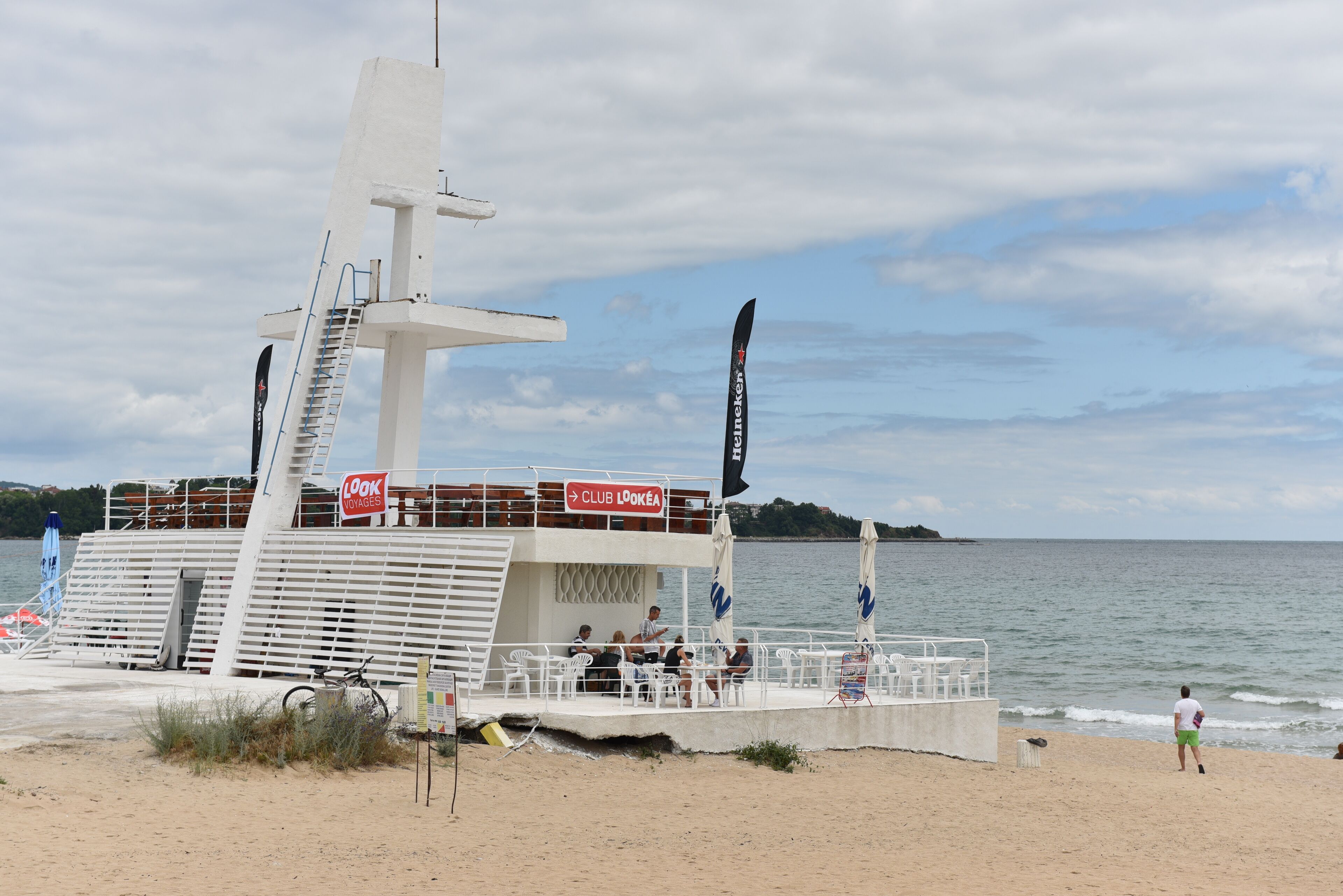Un bote en la playa con zona de cubierta, asientos y un letrero que dice 'Look Away'.