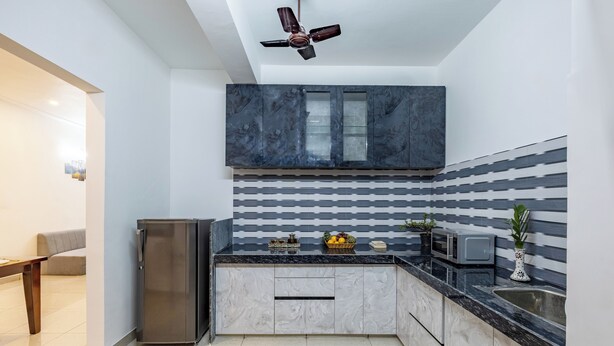 A modern kitchen with a refrigerator, microwave, and sink. - Alaya Stays with Balcony & Hill View | Lake City Heights (Udaipur)