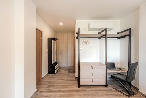Une chambre à coucher avec un lit, un bureau, une chaise et une armoire.