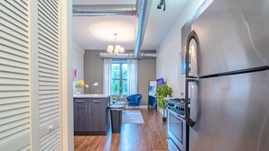 A modern kitchen with stainless steel appliances, a wooden floor, and a view of the living area. - Chicago Spacious 3Br Smoke Ok Near McCormick Place (Chicago)