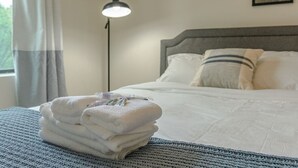 A neatly made bed with white linens and pillows, a bedside lamp, and a window with curtains. - Chicago Spacious 3Br Smoke Ok Near McCormick Place (Chicago)