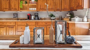 A wooden kitchen with cabinets, a coffee machine, and decorative items on the counter.