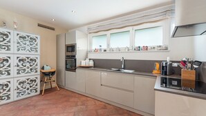 Una cucina moderna con isola centrale, forno integrato e finestra sopra il lavello.