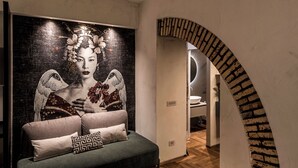 Interior moderno com um grande mural, um arco de tijolos curvo e um banheiro minimalista.