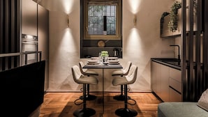 Uma cozinha compacta com área de refeições, com uma janela, eletrodomésticos modernos e design minimalista.