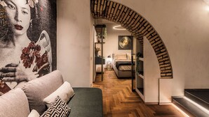 Um interior moderno com piso de madeira, um mural grande e um arco de tijolos curvo.