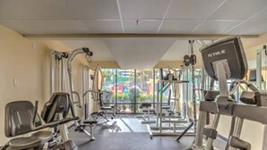 A gym with various exercise equipment, including treadmills and weight machines, with a view of a playground outside. - Cozy condo in wonderful Myrtle Beach with refreshing AC (Myrtle Beach)