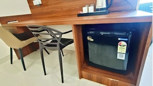 A compact kitchenette with a refrigerator, a coffee maker, and a power-saving sticker. - Hotel Krishna Anandam Regency (Vrindavan)