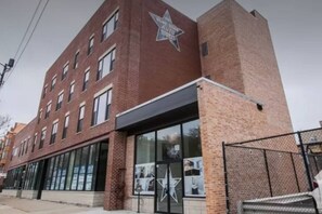 A multi-story brick building with a large glass storefront and a prominent star logo on the facade. - Spacious 3BR Smoke Ok | McCormick & UIC Campus (Chicago)