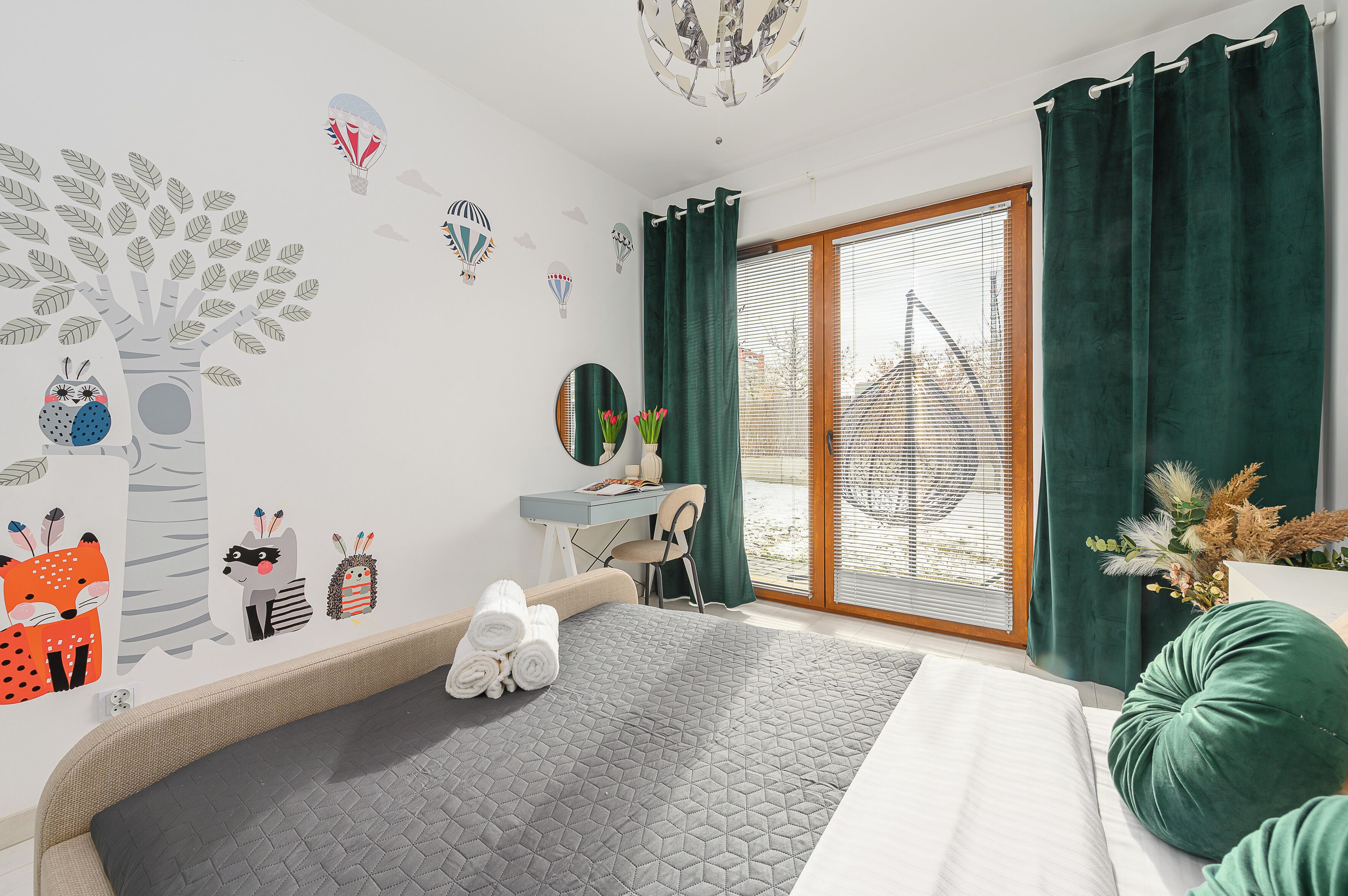 Una camera da letto con un letto, una scrivania, una sedia e una finestra con tende.