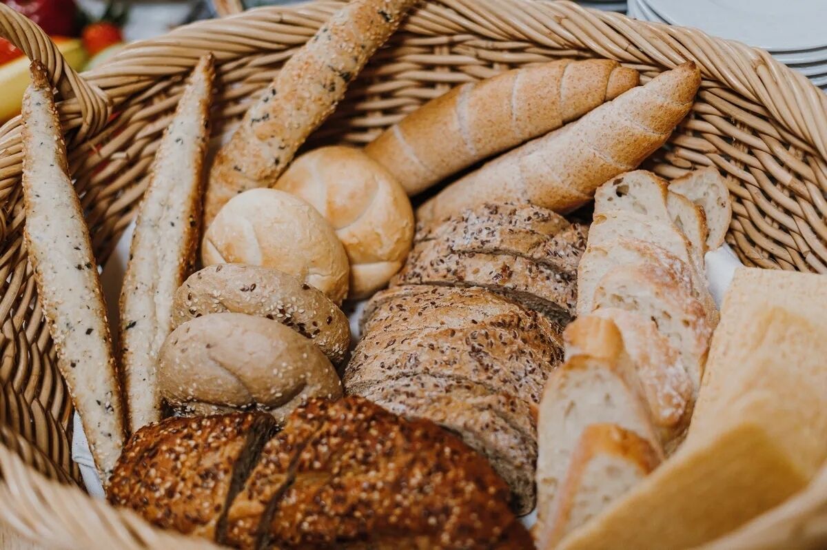 A wicker basket filled with various types of bread.