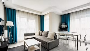 Un salon moderne avec un canapé, une table basse et un coin repas.