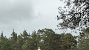 Una casa con tejado rojo, paredes blancas y una chimenea.