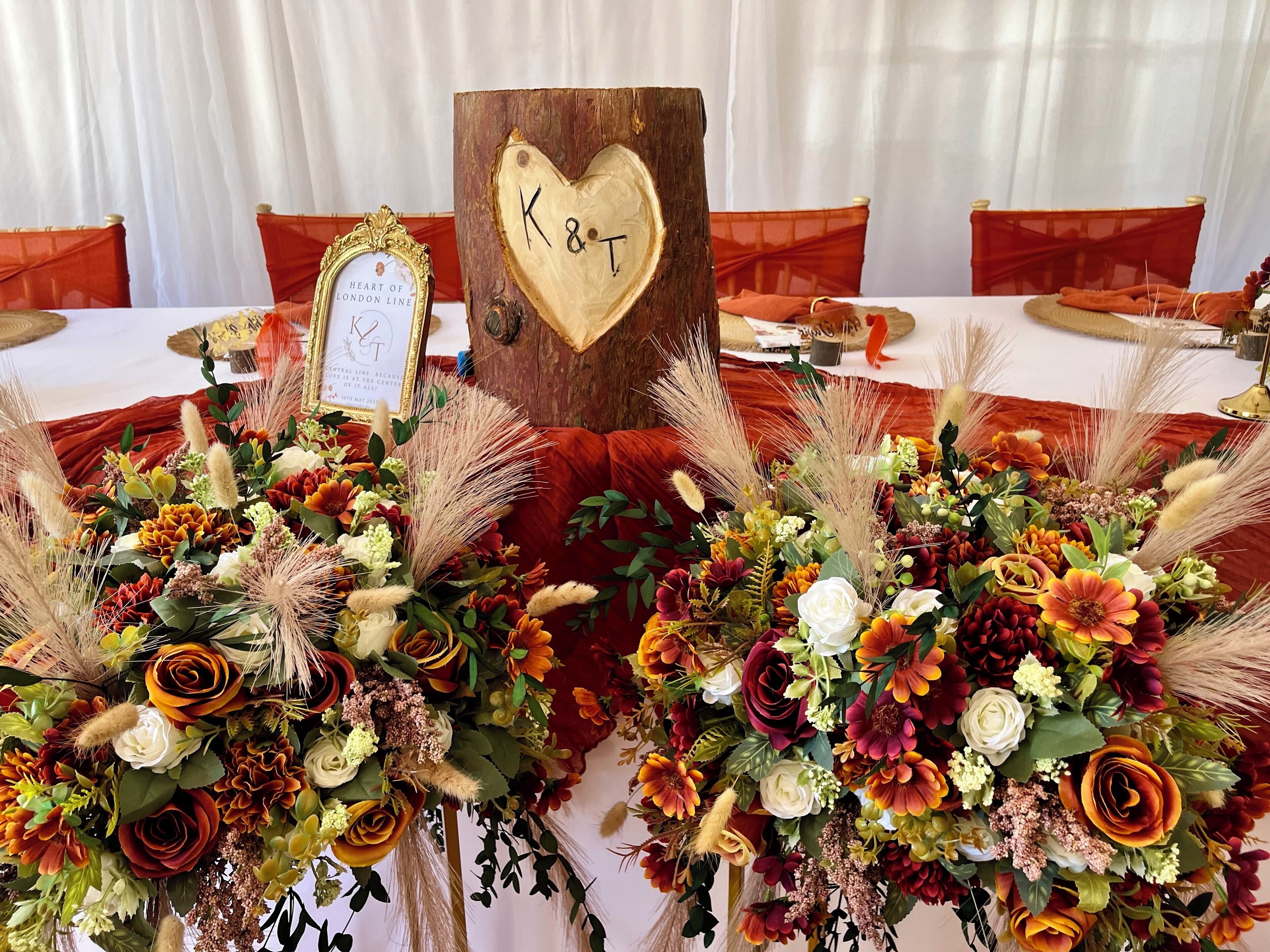 Una mesa con una decoración con forma de corazón de madera, con la etiqueta “K&T”, y un cartel enmarcado que dice “Heart of London Line”.