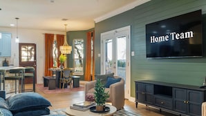 Una sala de estar moderna con un sofá, una mesa de centro y un televisor montado en la pared.