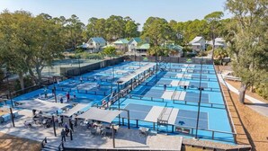 A large outdoor swimming pool with multiple lanes, surrounded by trees and residential buildings. - Private Pool | Walk to Beach | 3BR Retreat (Hilton Head Island)