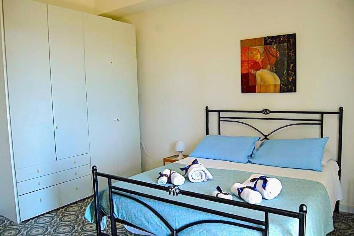 Un dormitorio con una cama, un armario y un cuadro en la pared.