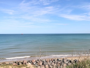 Una playa con costa rocosa y mar tranquilo.
