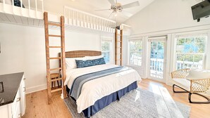 A bedroom with a bunk bed, a desk, a chair, a ceiling fan, and large windows. - Charming Carillon Home + Kid Friendly + Lots of Extras (Panama City Beach)