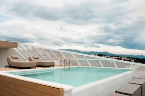 A rooftop pool with lounge chairs and a view of mountains. - Boutique Hotel Venturo, a Member of Design Hotels (Split)