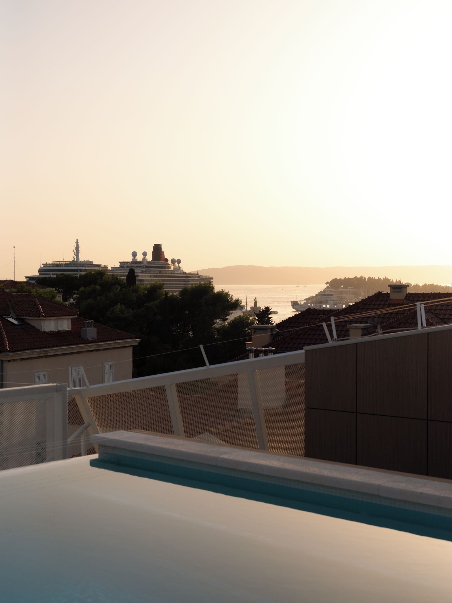 Zona de piscina con vista a un crucero y colinas al lejano.