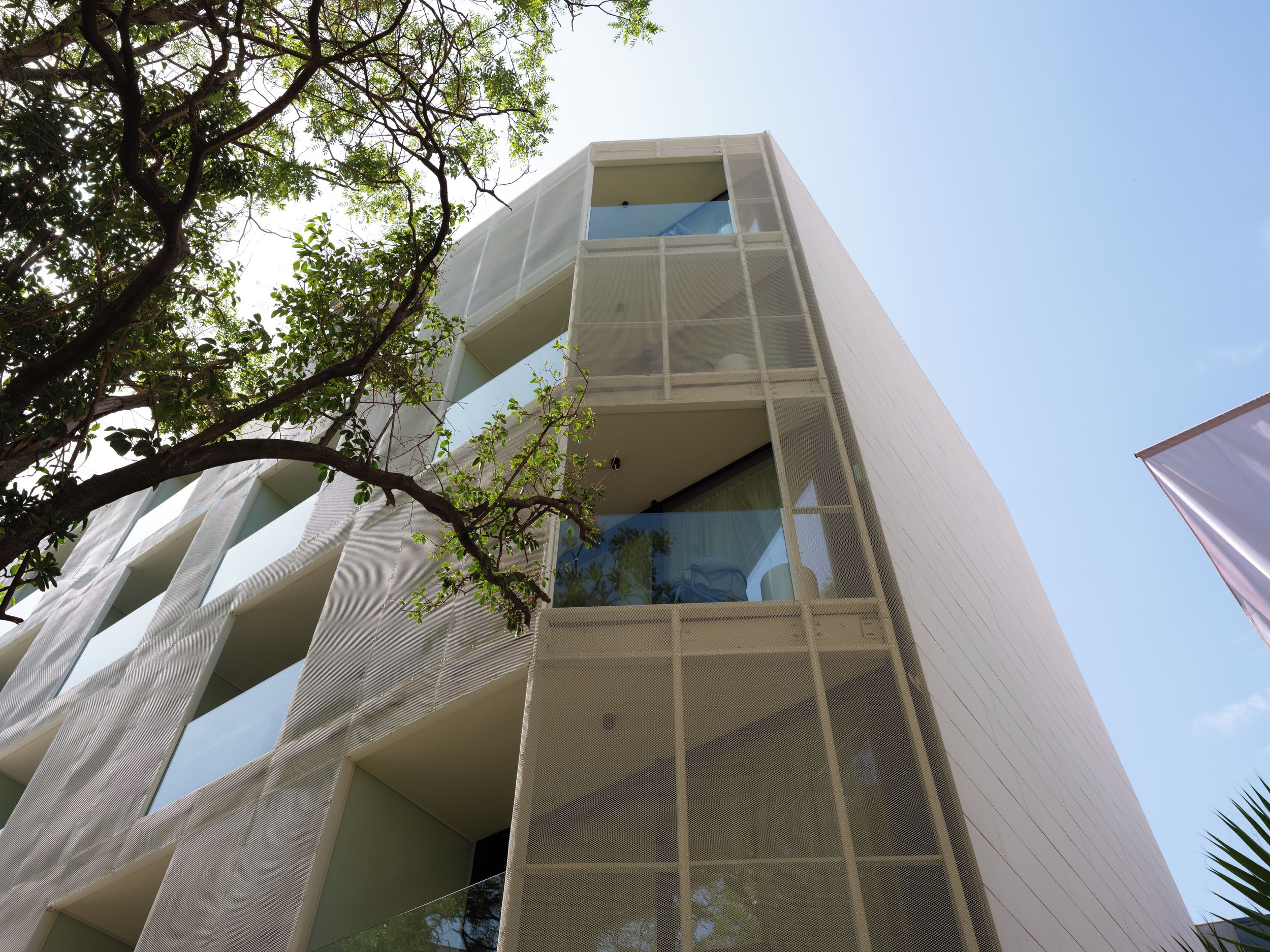Un edificio moderno con fachada singular que presenta patrones geométricos y balcones.
