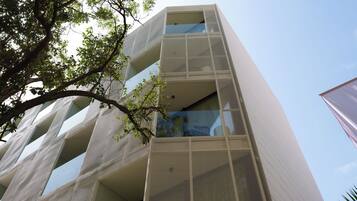 Un edificio moderno con fachada singular que presenta patrones geométricos y balcones.