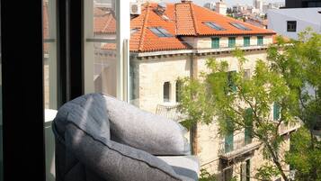 Ein Zimmer mit Blick auf Gebäude und einen Baum.