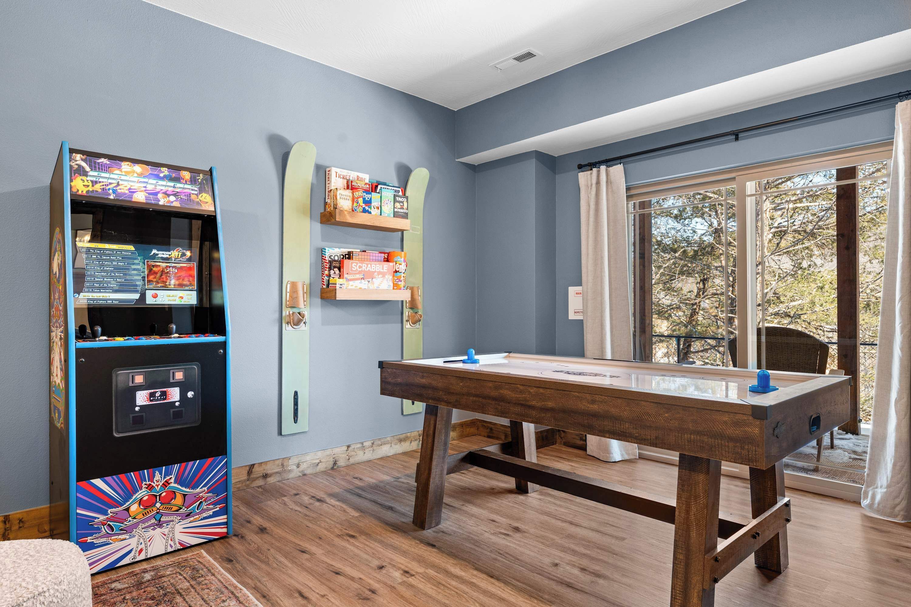 A room with a pool table, a foosball table, and shelves with board games.