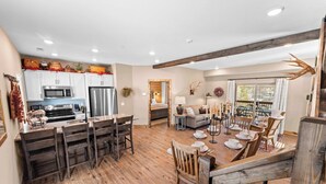 A spacious kitchen with modern appliances, a dining area with wooden furniture, and a cozy living space with a fireplace.