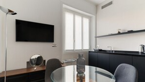 A modern kitchen with a black countertop, a round glass table, and a large window. - GuestHost - A cozy and bright apartment of approximately 35 square meters, perfect for two people, located on the second floor of a building with an elevator (NOT accessible to disabled guests).The property is located in a central area of ​​Milan and (Milan)