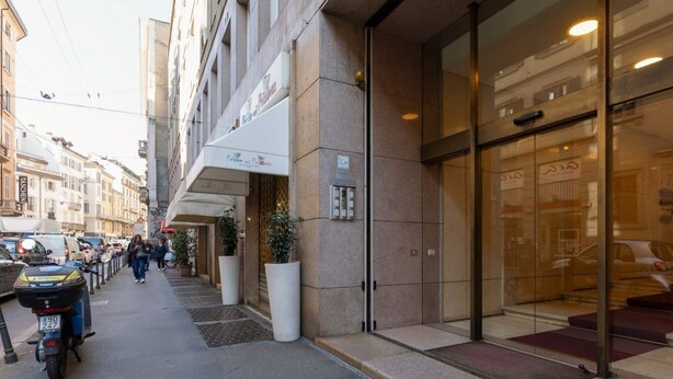 A hotel entrance with a glass door, a potted plant, and a sign above the door. - GuestHost - A cozy and bright apartment of approximately 35 square meters, perfect for two people, located on the second floor of a building with an elevator (NOT accessible to disabled guests).The property is located in a central area of ​​Milan and (Milan)