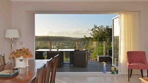 Ein modernes Wohnzimmer mit Essbereich, eine große Glasschiebetür führt zu einem Balkon mit schöner Aussicht.