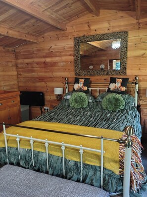 A wooden cabin bedroom with a bed, a mirror, and a dresser. - Forest Cabin Retreat-sleeps 2-garden, Wifi, Trails (Fordingbridge)