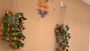 Deux suspensions fleuries, ornées de roses, sont accrochées à un mur sobre.