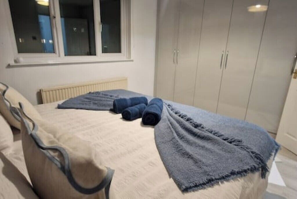 Un dormitorio con cama, ventana y armario.