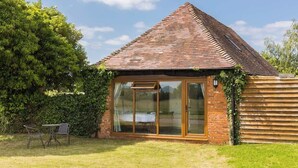 A small brick house with a sloped roof, large sliding glass doors, and a wooden fence. - Rural, Self-Contained 1Bed, The Writer's Retreat (Hampton Lucy)