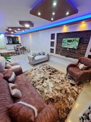 Departamento Deluxe, balcón, vista a la ciudad | Área de sala de estar