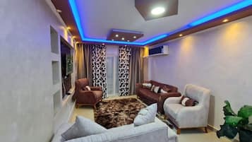 Departamento Deluxe, balcón, vista a la ciudad | Área de sala de estar