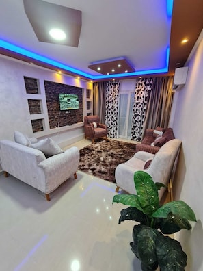 Departamento Deluxe, balcón, vista a la ciudad | Área de sala de estar