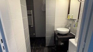 Un baño pequeño con inodoro blanco, lavamanos y espejo.